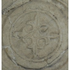 Fleur-de-lis solar cross inside a circle on a marble stone